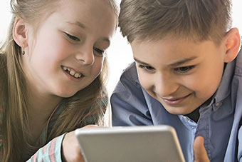 Two children reading using a tablet